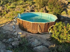 a large wooden bath tub sitting on top of rocks at El Encuentro - Casa Rural - in Arenas de San Pedro