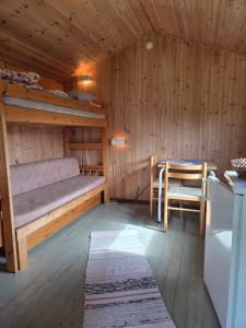 a room with a bed and a table in a cabin at Sonjas Camping & Stugor in Löttorp