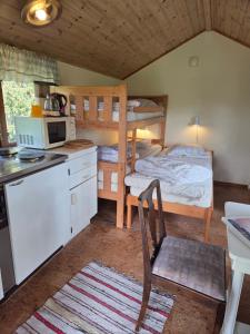 a room with a kitchen and a bunk bed at Sonjas Camping & Stugor in Löttorp