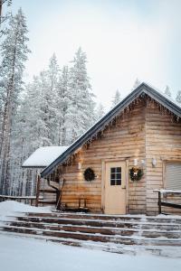a log cabin with snow on the steps at Livo Arctic Resort in Posio