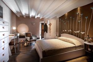 Boutique Hotel Villa dei Campi في غافاردو: غرفة نوم بسرير ومكتب وكرسي