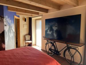 a bedroom with a tv and a bike on a wall at Lo Blan Morgex in Morgex