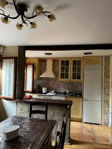 a kitchen with a table and a refrigerator at Ibón de la Sierra in El Pueyo de Jaca
