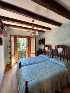 a bedroom with a large bed with a blue comforter at Ibón de la Sierra in El Pueyo de Jaca