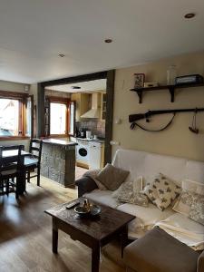 a living room with a couch and a table at Ibón de la Sierra in El Pueyo de Jaca +10 photos