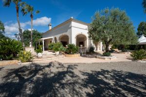 a white house with palm trees in front of it at Villa Tonia in Fasano