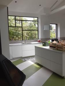 a kitchen with white cabinets and a large window at Pan Demeure et Granges in Montesquieu-Avantès