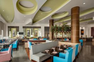 a dining room with tables and blue chairs at Ramada by Wyndham Bodh Gaya Mahabodhi in Bodh Gaya
