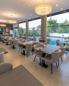 a restaurant with tables and chairs and a large window at Rossa Marin Hotel in Darıca