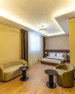 a hotel room with a bed and two chairs and tables at Rossa Marin Hotel in Darıca +11 photos