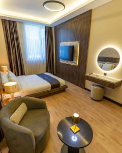 a hotel room with a bed and a chair at Rossa Marin Hotel in Darıca