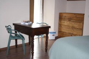 a bedroom with a desk and two chairs and a bed at La Becca Morgex in Morgex