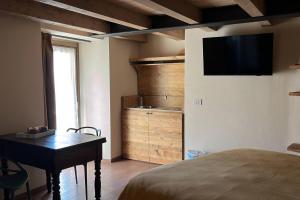 a bedroom with a bed and a desk and a television at La Becca Morgex in Morgex