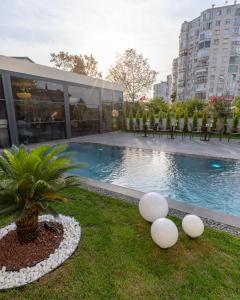 a building with a pool and a palm tree next to a building at Rossa Marin Hotel in Darıca