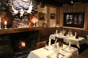 a restaurant with two tables in front of a fireplace at Taufsteinhütte in Schotten