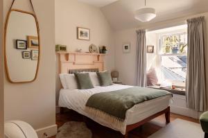 a bedroom with a bed with a mirror and a window at Home Farm in Oban