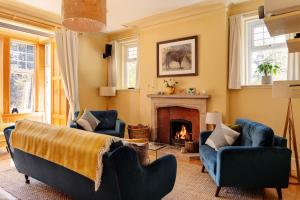 a living room with two blue chairs and a fireplace at Home Farm in Oban