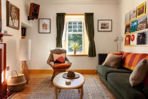 a living room with a couch and a chair at Home Farm in Oban