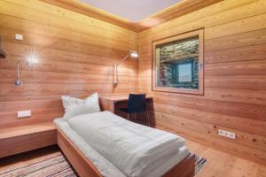 a bedroom with a bed in a wooden room at Chalet Oberjuval in Kastelbell-Tschars