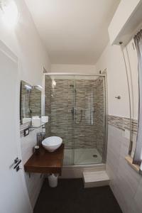 a bathroom with a glass shower with a sink and a toilet at Il mare di Giulio in Marcelli