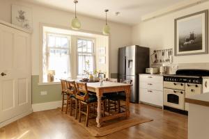 a kitchen with a wooden table and a refrigerator at Home Farm in Oban +73 photos