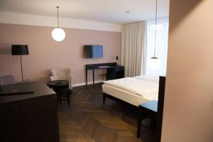 a bedroom with a bed, chair, and a lamp at Hotel Caroline in Vienna