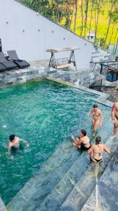 a group of people in a swimming pool at Lotus Premium Lodge in Ha Giang