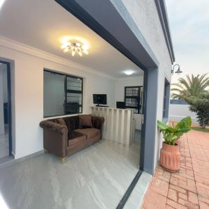 a living room with a couch and a window at Cozy Villa Lodge in Edenvale