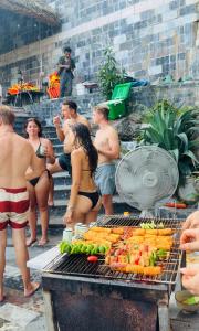 a group of people standing around a barbecue grill at Lotus Premium Lodge in Ha Giang