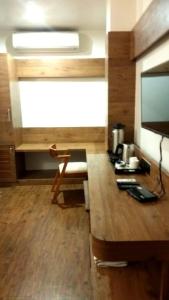 a room with a desk with a television and a table at Hotel Aravali in Mount Ābu +6 photos