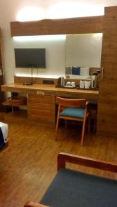 a room with a desk with a television and a chair at Hotel Aravali in Mount Ābu