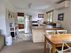 a kitchen with a refrigerator and a table and chairs at Stewarts Bay Retreat in Port Arthur +14 photos
