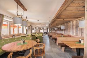 a restaurant with wooden tables and green chairs at Radstädter Hütte am Rossbrand in Radstadt