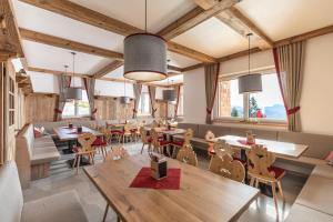 a dining room with tables and chairs and windows at Radstädter Hütte am Rossbrand in Radstadt +39 photos
