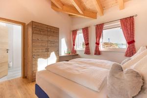 a bedroom with a bed and two windows at Radstädter Hütte am Rossbrand in Radstadt