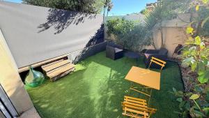 a garden with a bench and a table and chairs at Studio avec jardin privé et parking gratuit in Mudaison