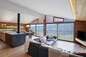 a living room with a couch and a kitchen with a view at Chalet Oberjuval in Kastelbell-Tschars