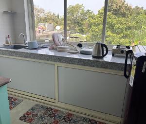 a kitchen counter with a sink and a window at The Ashvem Horizon in Mandrem