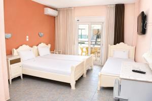 a hotel room with two beds and a balcony at Hotel Dionysos Polichrono in Polychrono