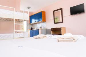 a kitchen with blue cabinets and towels on a bed at Hotel Dionysos Polichrono in Polychrono