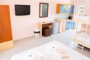 a living room with a kitchen with a tv on the wall at Hotel Dionysos Polichrono in Polychrono +49 photos