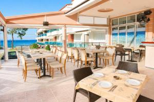 a restaurant with tables and chairs and the ocean at Hotel Dionysos Polichrono in Polychrono