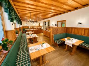 an empty restaurant with wooden tables and benches at MÜHLBACHER - inklusive kostenfreiem Eintritt in die Alpentherme in Bad Hofgastein