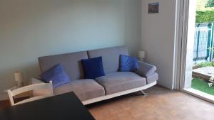 a couch with blue pillows in a living room at Entre Golf et Mer RDC in Dieppe