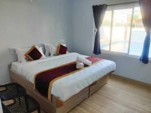 a bedroom with a large bed with a window at Hotel O CANARIES RETIREES RESIDENCY in Kottakupam