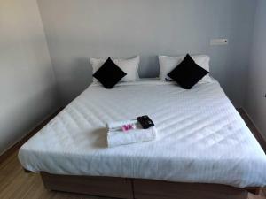 a white bed with two towels on top of it at Hotel O CANARIES RETIREES RESIDENCY in Kottakupam
