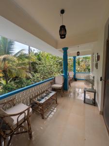 a porch with chairs and a blue wall at Amore Holiday Home in Canacona