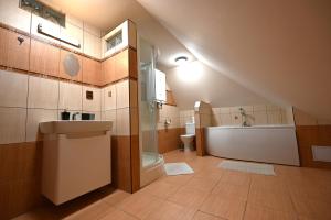 a bathroom with a sink and a toilet and a tub at Penzión Kállai a Vináreň in Fiľakovo +49 photos