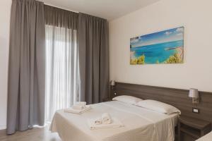 a bedroom with a bed with two towels on it at Il mare di Giulio in Marcelli