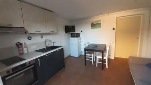 a kitchen with a sink and a table in it at Entre Golf et Mer RDC in Dieppe